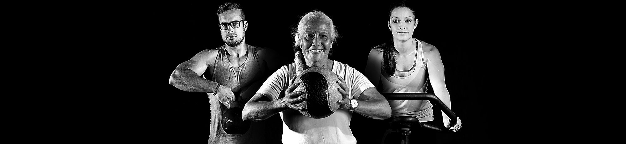 Three Smart Fitness members training together — kettlebell, medicine ball, and spin bike